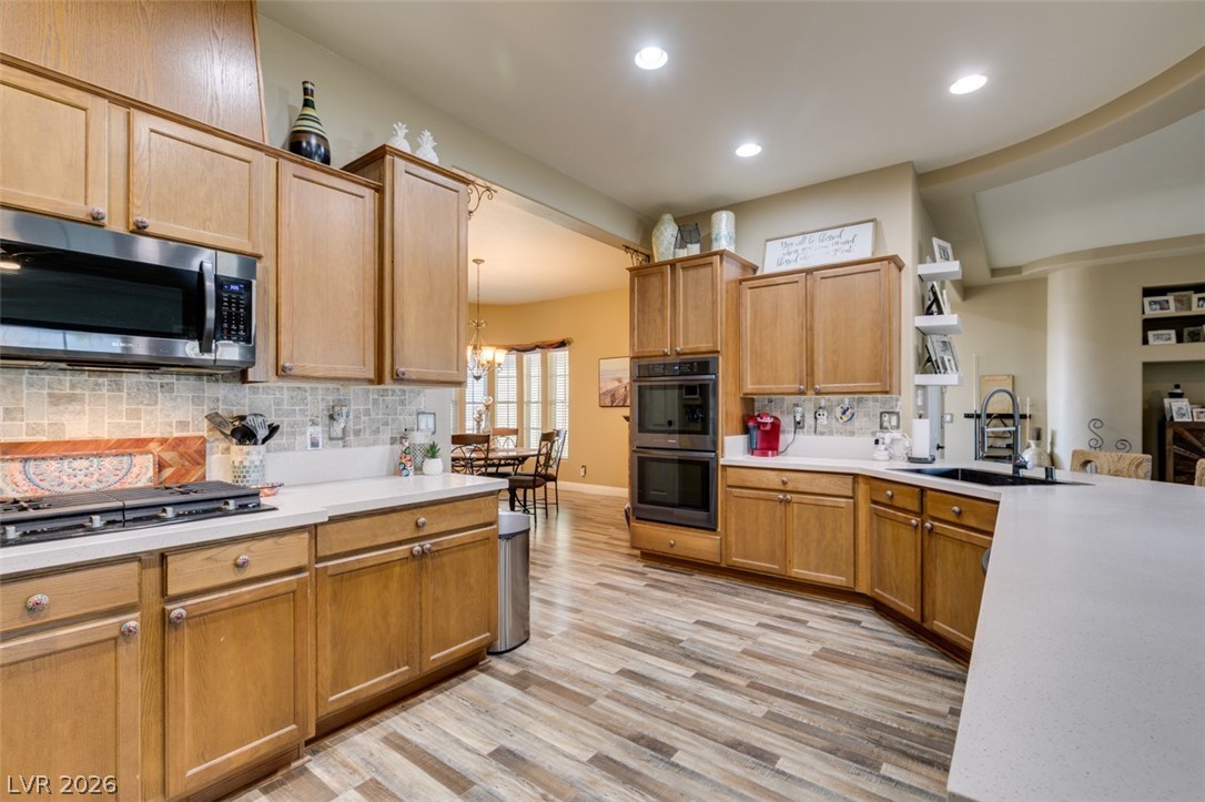 7524 Midnight Rambler Street Las Vegas, NV 89149 - Photo 21 of 51 Natural light illuminates a modern kitchen featuring wood cabinetry and sleek appliances.