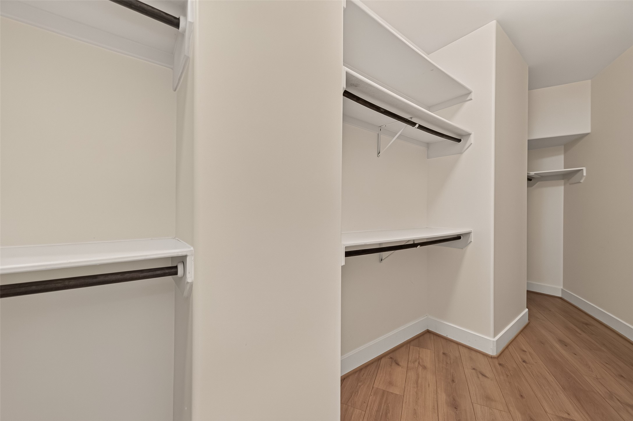 1767 Michigan Street Houston, TX 77006 - Photo 25 of 33 Spacious walk-in closet with multiple shelves and hanging rods, featuring hardwood floors and neutral walls for a clean, organized look.
