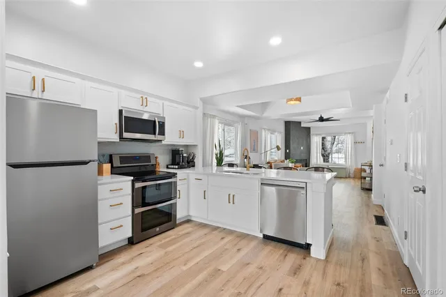 a kitchen with white cabinets and stainless steel appliances