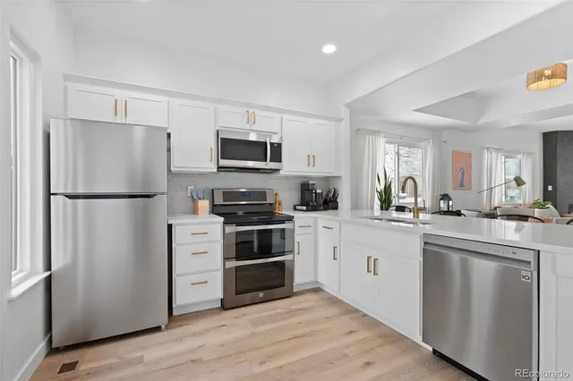 a kitchen with white cabinets and stainless steel appliances