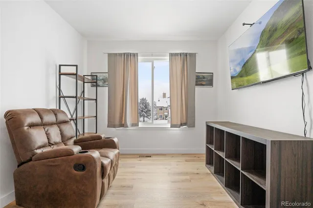 a living room with furniture a window and wooden floor