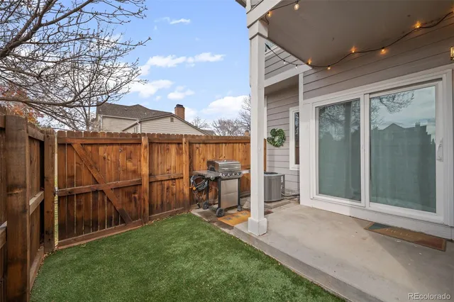 a view of a backyard with wooden floor and iron fence