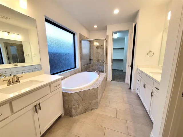 a bathroom with a granite countertop sink a mirror a bathtub and shower