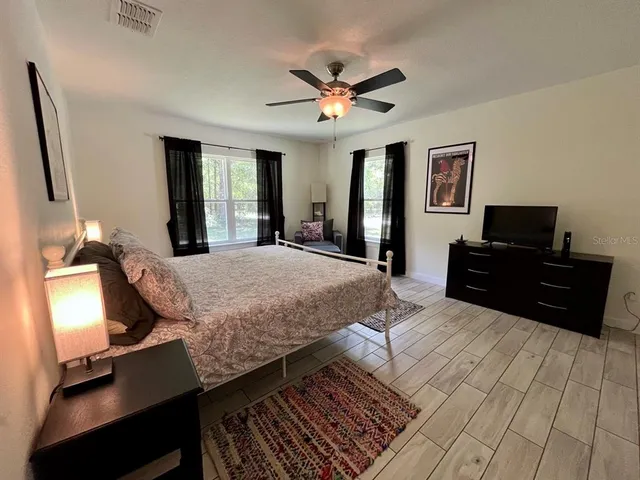 a bed room with a bed window and a flat screen tv