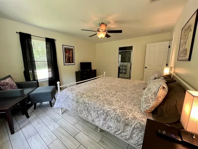 a bed sitting in a spacious bedroom next to a window