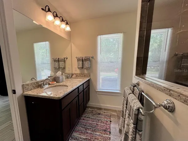 a bathroom with a double vanity sink and a mirror