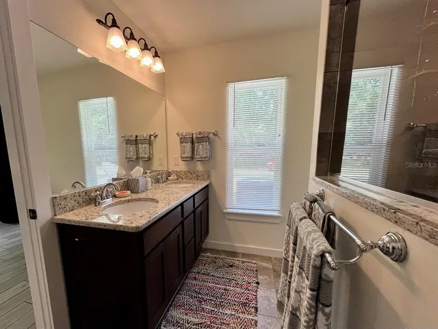 a bathroom with a double vanity sink and a mirror