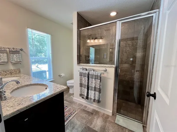 a bathroom with a granite countertop sink mirror and shower