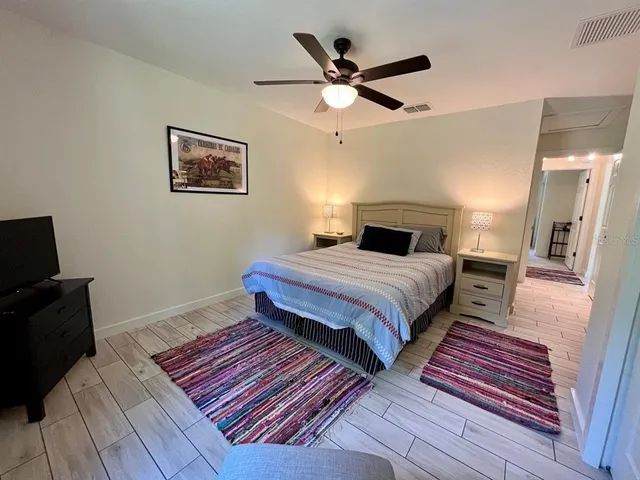 a bedroom with a large bed and a ceiling fan