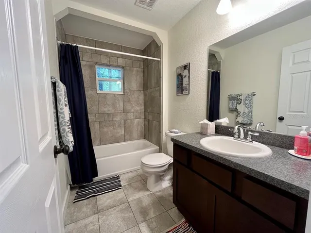 a bathroom with a double vanity sink toilet mirror and shower