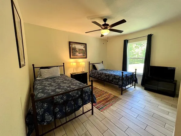 a bedroom with two beds and a flat screen tv