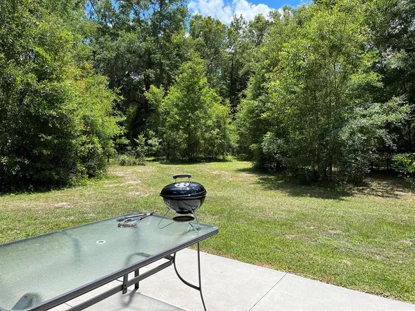 a view of a backyard with table and chairs and potted plants