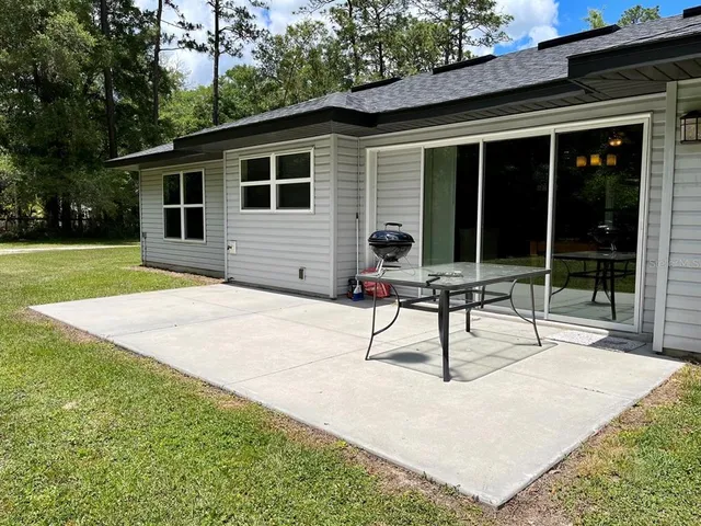 a view of a house with backyard and sitting area