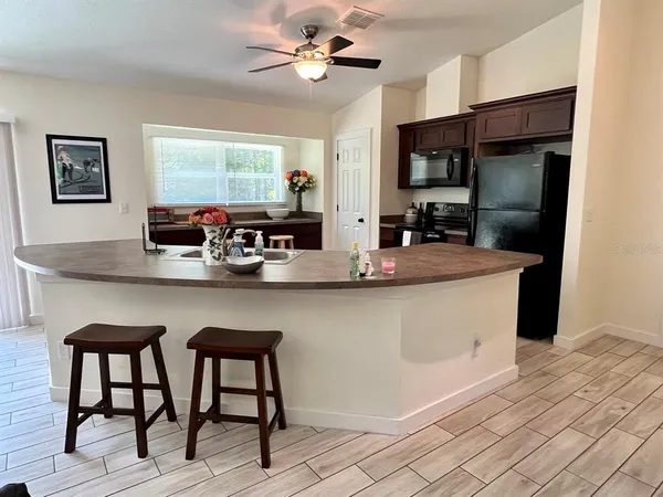 a kitchen with stainless steel appliances granite countertop a sink counter space and a refrigerator