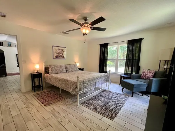 a bedroom with a bed wooden floor and windows