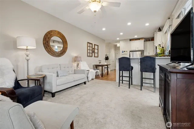 a living room with furniture a clock and a flat screen tv