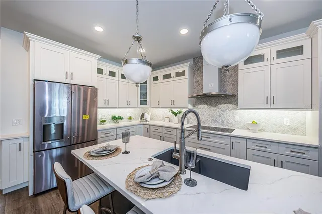 a kitchen with stainless steel appliances granite countertop a sink refrigerator and cabinets