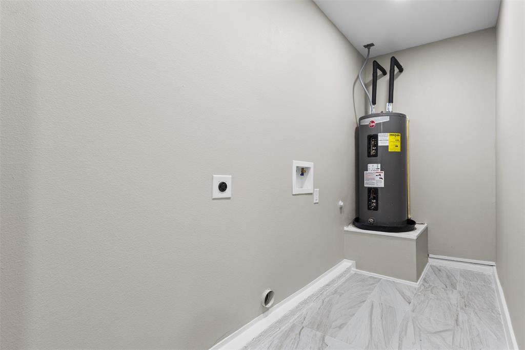 1903 Beauford Road Dallas, TX 75253 - Photo 27 of 27 Water heater with a raised platform, light-toned wall paint, and wood-finish flooring
