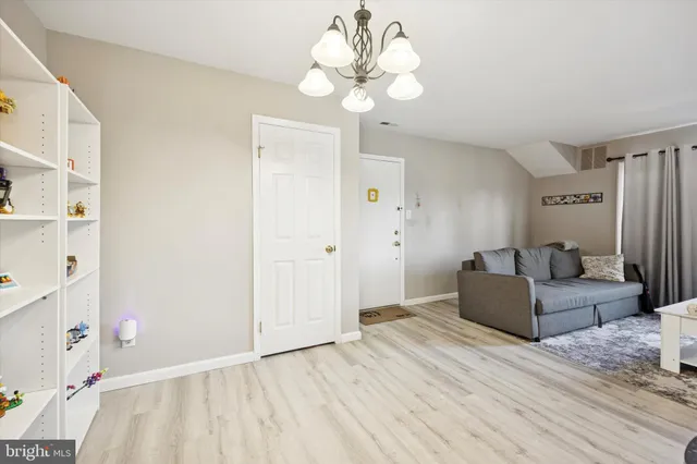 a living room with furniture and a chandelier