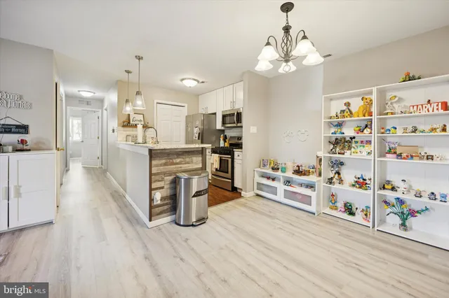 a kitchen with stainless steel appliances wooden floor and large windows