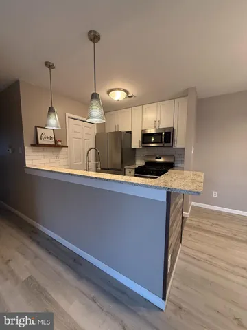 a kitchen with stainless steel appliances granite countertop a sink a stove and a refrigerator