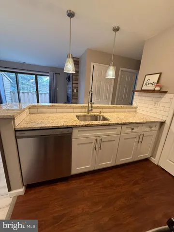 a kitchen with a sink and a wooden floor