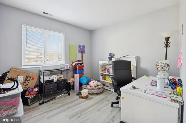 a view of a workspace with furniture and a window