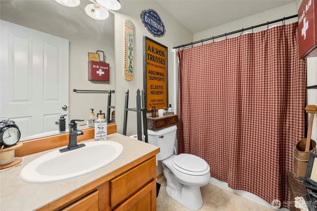 a bathroom with a sink a toilet and shower curtain