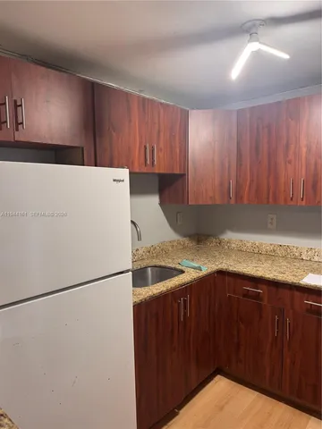 a kitchen with a refrigerator and a sink