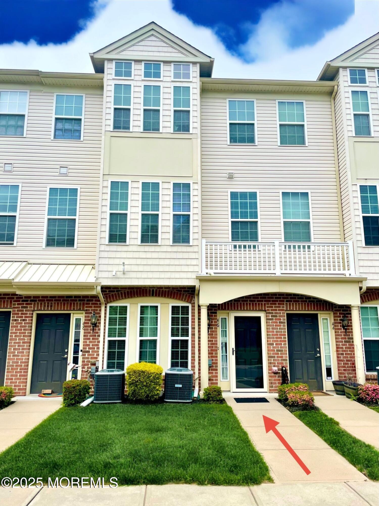 a front view of a brick building with a yard