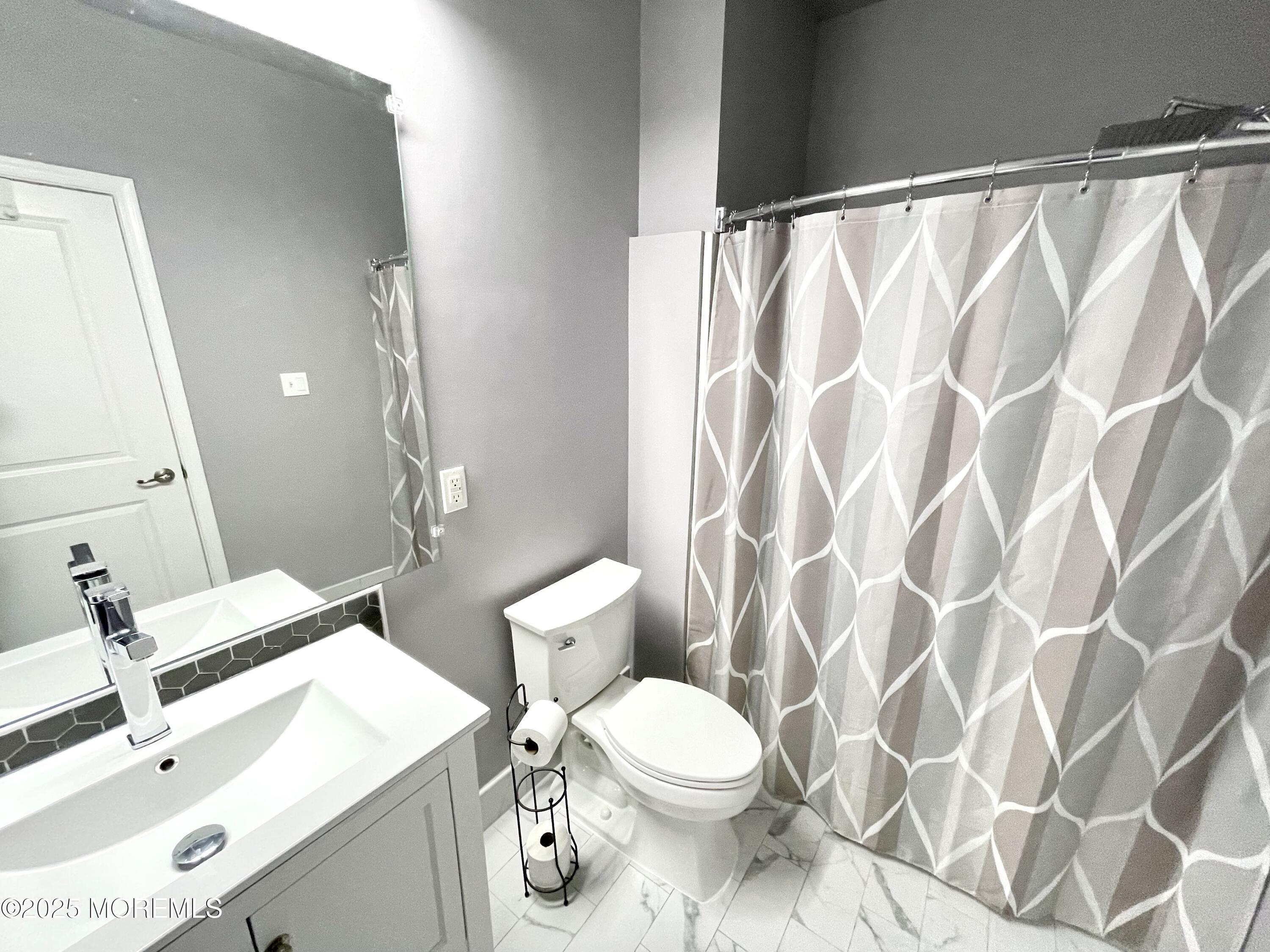 46 Michael Drive Tinton Falls, NJ 07712 - Photo 16 of 16 a bathroom with a sink and a mirror