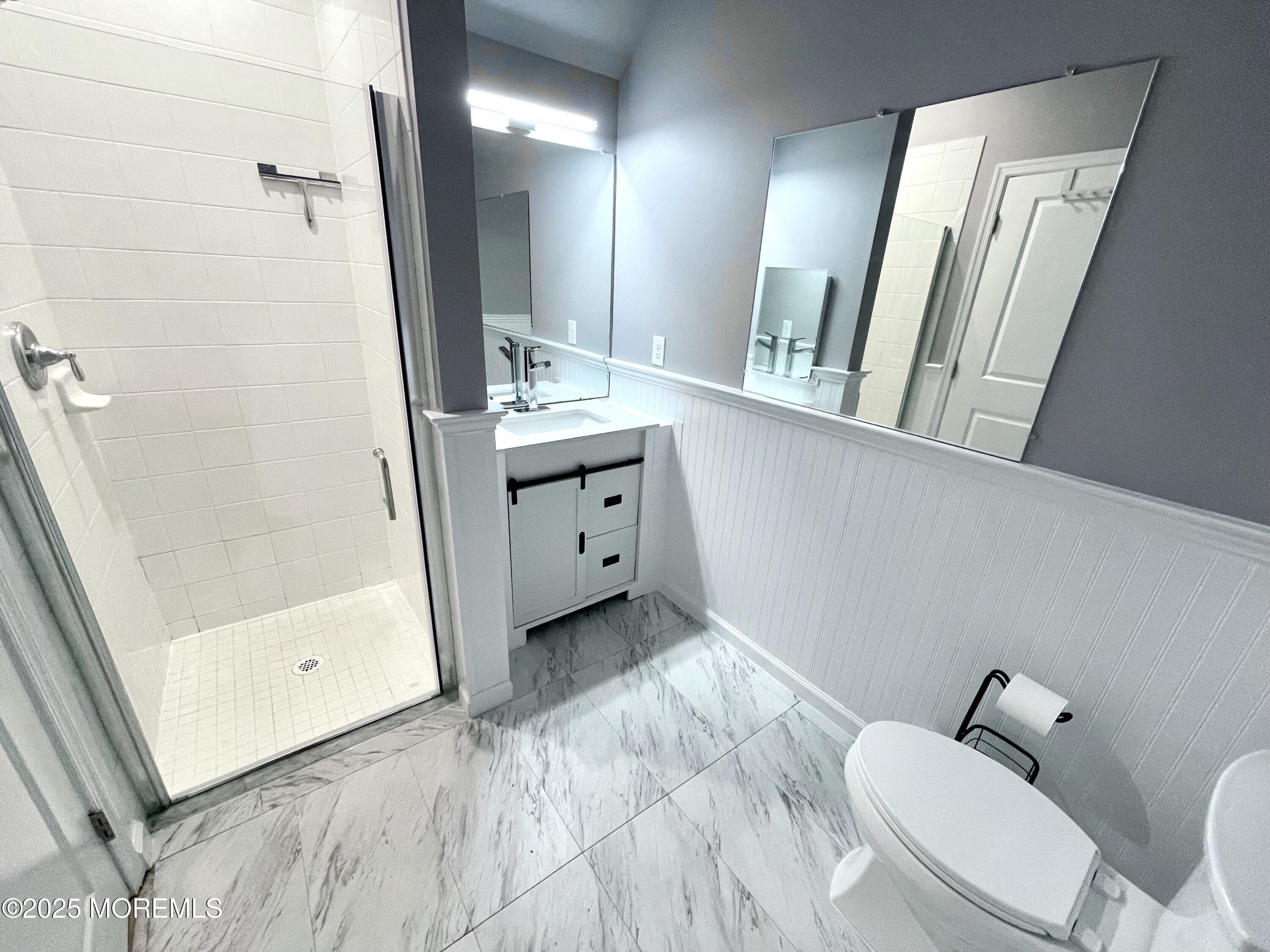 46 Michael Drive Tinton Falls, NJ 07712 - Photo 8 of 16 a bathroom with a sink a toilet a mirror and shower