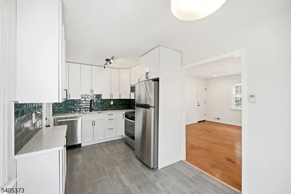 a kitchen with stainless steel appliances granite countertop a refrigerator a stove and a sink