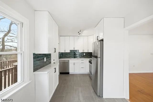 a kitchen with a refrigerator a stove top oven and cabinets