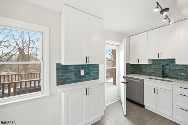 a kitchen with white cabinets and a sink