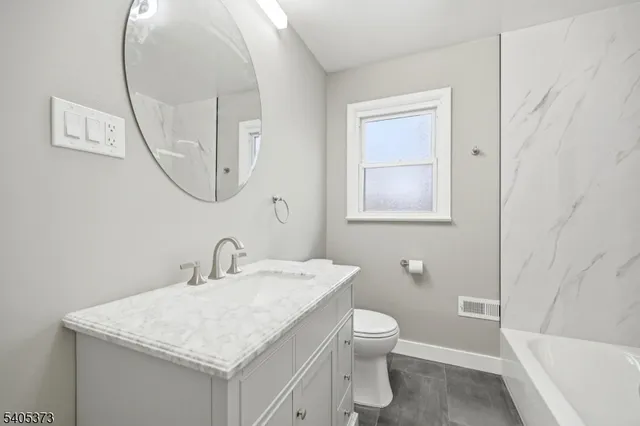 a bathroom with a sink toilet and a mirror