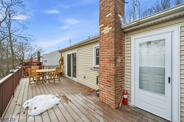 a view of a patio with table and chairs with wooden floor and fence