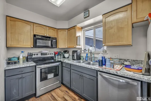 a kitchen with stainless steel appliances granite countertop a sink a stove and cabinets
