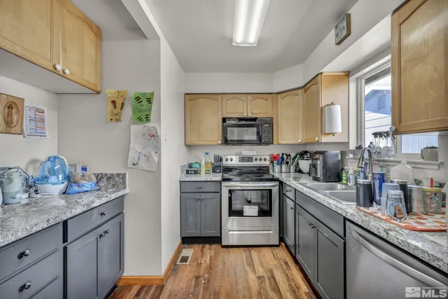 a kitchen with stainless steel appliances granite countertop sink stove top oven and cabinets