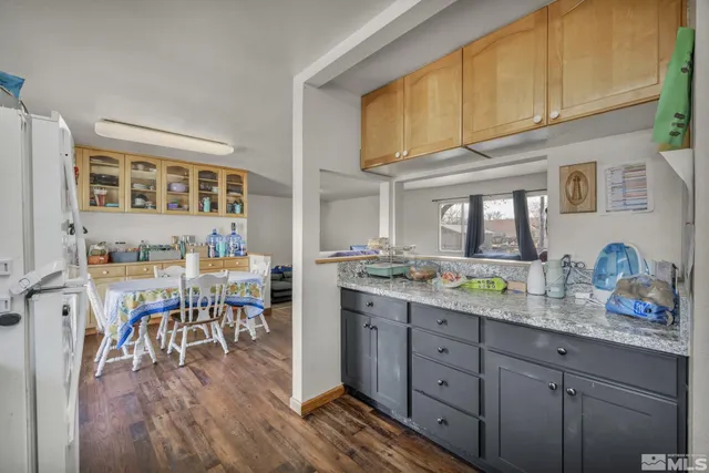 a open kitchen with granite countertop a sink cabinets and wooden floor