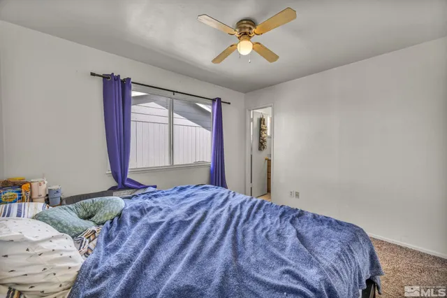 a bedroom with a large bed and a window