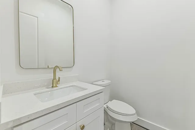 an empty room with wooden floor and a ceiling fan