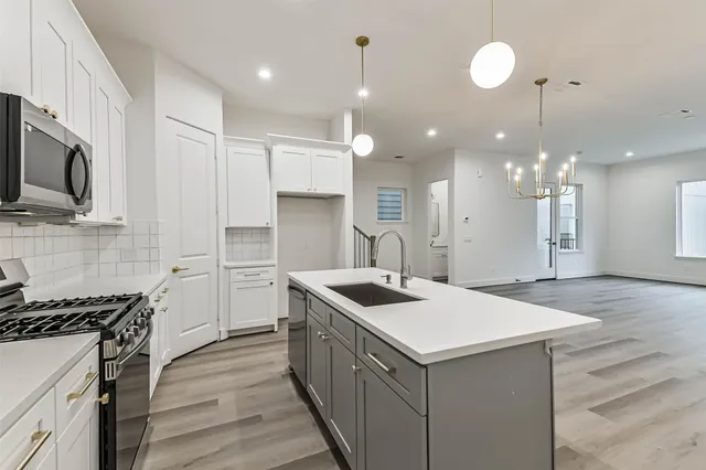 a view of kitchen with sink and refrigerator