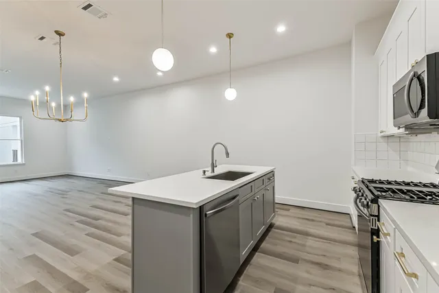 a kitchen with kitchen island a sink stainless steel appliances and cabinets