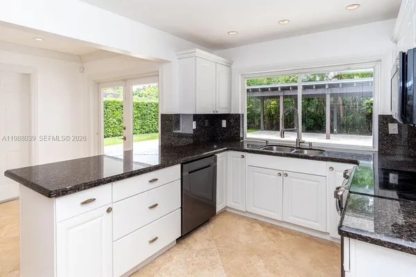 a kitchen with stainless steel appliances granite countertop a refrigerator and a sink