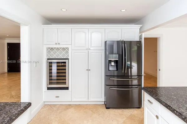 a kitchen with kitchen island granite countertop a stove top oven a sink a counter space and cabinets