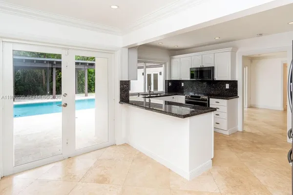 a kitchen with granite countertop a refrigerator and a stove