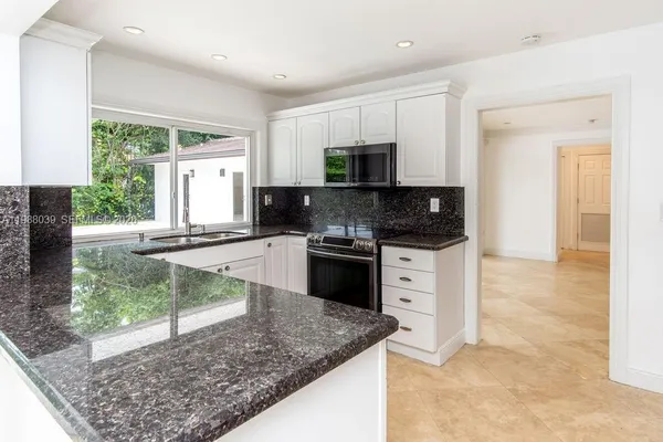 an empty room with windows and ceiling fan