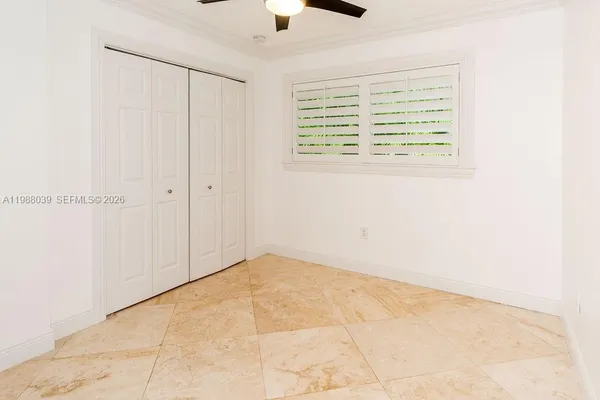 an empty room with closet and a ceiling fan