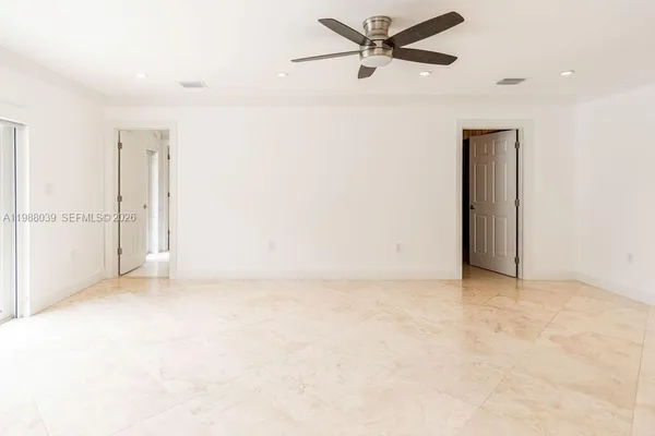 an empty room with chandelier fan